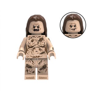 May include: A plastic minifigure with long brown hair and a tan complexion. The torso and legs feature printed brown markings resembling dirt or skin texture. The face has an angry expression with visible teeth, and an inset shows a smiling face.