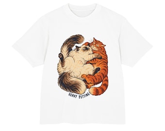 May include: A white short-sleeved t-shirt featuring a graphic illustration of a fluffy cream-coloured cat and an orange tabby cat cuddling. Below the cats, the text HEAVY PETTING is printed in dark blue capital letters on the front of the shirt.