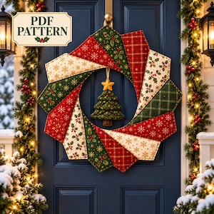 May include: A fabric Christmas wreath featuring a patchwork design of red, green, and cream panels with snowflake, holly, and plaid patterns. A small stuffed fabric Christmas tree with a yellow star hangs in the centre. Text reads PDF PATTERN.