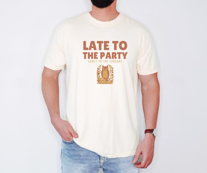 Ivory Comfort Colors t-shirt printed with the words Late To The Party Early To The Library and a drawing of a woodland owl wearing spectacles sitting on a book, worn by a man