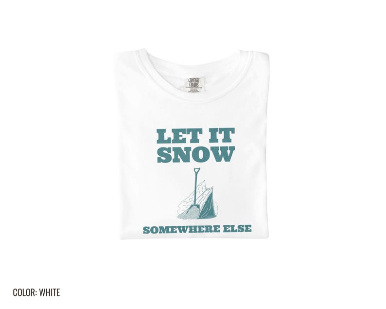 White Comfort Colors t-shirt printed with the words Let It Snow Somewhere Else and a drawing of a metal snow shovel propped beside an empty bag of rock salt, folded flat lay