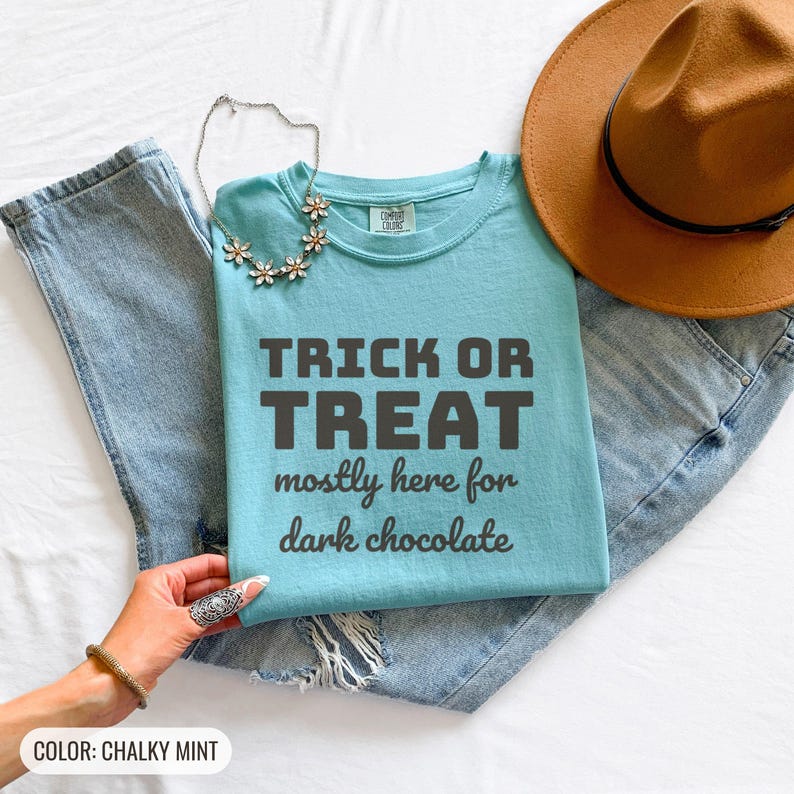 Chalky Mint Comfort Colors t-shirt printed with the words Trick Or Treat Mostly Here For Dark Chocolate, folded flat lay