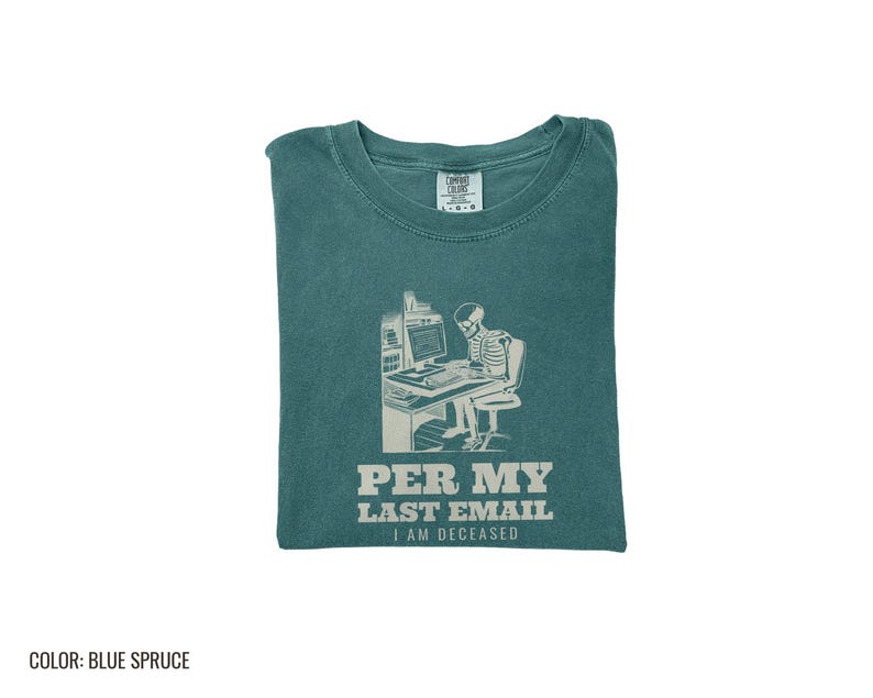 Blue Spruce Comfort Colors t-shirt printed with the words Per My Last Email I Am Deceased and a drawing of a skeleton sitting at an office desk typing on a computer keyboard, folded flat lay