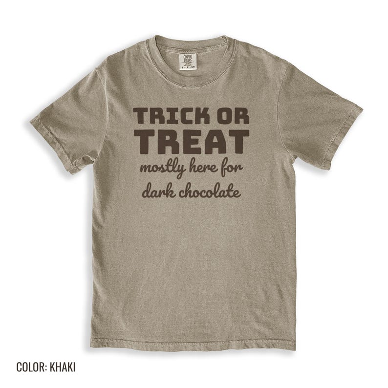 Khaki Comfort Colors t-shirt printed with the words Trick Or Treat Mostly Here For Dark Chocolate, folded flat lay