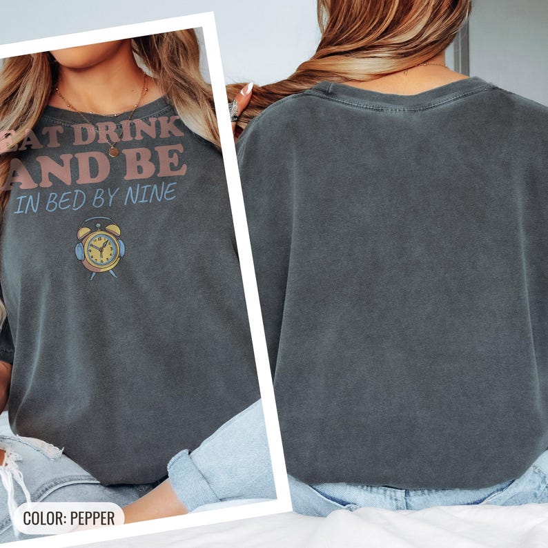 Pepper Comfort Colors t-shirt printed with the words Eat Drink And Be In Bed By Nine and a drawing of a retro brass wind-up alarm clock with its bells wrapped in fuzzy winter earmuffs, worn by a woman