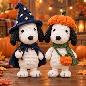 May include: Two crocheted white dog figures with black ears. The left figure wears a dark blue wizard hat with yellow stars and a matching cape, holding a brown wand. The right figure wears an orange pumpkin hat and a green scarf with a small pumpkin bag.
