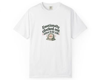 Puede incluir: Una camiseta blanca de manga corta con un gráfico en el pecho que incluye el texto "Emotionally clocked out since 9:02 AM" en letras oscuras, acompañado de la ilustración de un pequeño reloj analógico con ojos cerrados y manecillas rojas.
