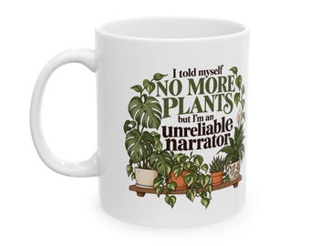 Puede incluir: Una taza de cerámica blanca con un gráfico de varias plantas en macetas sobre un estante y el texto I told myself NO MORE PLANTS but I'm an unreliable narrator impreso en letras verde oscuro y marrón en el centro.