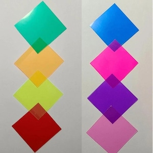 May include: Two vertical columns of overlapping square sheets in various translucent colors. The left column features green, orange, yellow, and red squares. The right column displays blue, hot pink, purple, and light pink square sheets.