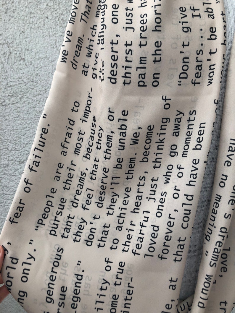 May include: A light-colored fabric with a repeating text pattern in black. The text includes phrases like "fear of failure" and "don't give fears." The fabric is folded, revealing a light blue edge.