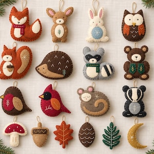 May include: A collection of felt ornaments featuring various woodland animals, including a fox, squirrel, hedgehog, raccoon, bear, and badger, alongside birds, a mushroom, an acorn, leaves, a pinecone, and a crescent moon, each with a hanging loop.