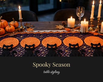 May include: A purple and orange crochet table runner featuring repeating motifs of black cats sitting in front of orange circular suns. The runner is decorated with small gold stars and text that reads CROCHETBYWHIMSY, Spooky Season, and table styling.