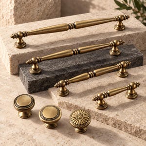May include: A collection of antique brass cabinet hardware including four elongated bar pulls with rounded finials and three circular knobs featuring smooth, beaded, and radial sunburst patterns with a brushed metallic finish.