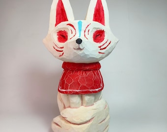 May include: A hand-carved wooden figurine of a fox with a white body, red painted accents on the ears, eyes, and cheeks, and a light blue vertical stripe on the forehead. The fox wears a red garment and sits atop a large, textured white tail.