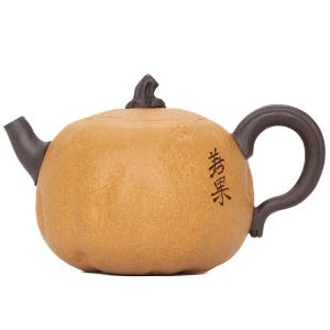 Op de afbeelding: Een pompoenvormige theepot met een getextureerd beige lichaam en donkerbruine accenten op de tuit, het handvat en de dekselknop. De theepot heeft verticaal geplaatste zwarte Chinese karakters gegraveerd op de zijkant van het lichaam.