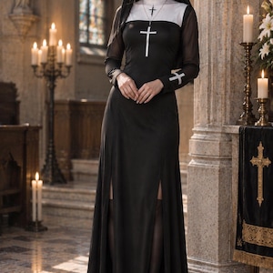 May include: A floor-length black dress with long sheer sleeves, a white high collar, and two front leg slits. The garment features a white cross emblem on the chest and cuffs, paired with a black and white headpiece and a silver cross necklace.