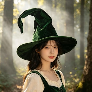 May include: A dark green velvet witch hat with a tall, pointed, and slightly curved crown and a wide, flexible brim. The hat is crafted from a soft, plush fabric that catches the light, creating subtle highlights across its surface.