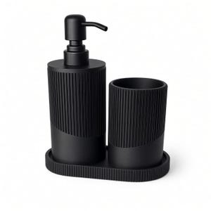 May include: A matte black bathroom accessory set consisting of a soap dispenser with a pump, a cylindrical tumbler, and an oval tray. Each piece features a vertical ribbed texture on the upper portion and a smooth finish on the lower section.