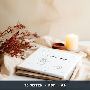 May include: A white booklet titled Mein Winterheft with black line drawings of a snowman and a penguin. The cover features small snowflake icons and text including 30 Seiten, PDF, and A4. The booklet is placed on a flat surface.