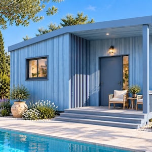 May include: A light blue, single-storey cabin with vertical wood siding, a flat roof, and a covered front porch. The structure features a dark blue front door, multiple windows, and a small outdoor seating area with two chairs and a side table.