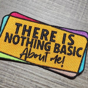 May include: A yellow patch with a colorful border reads "There is nothing basic about me!" in black text.