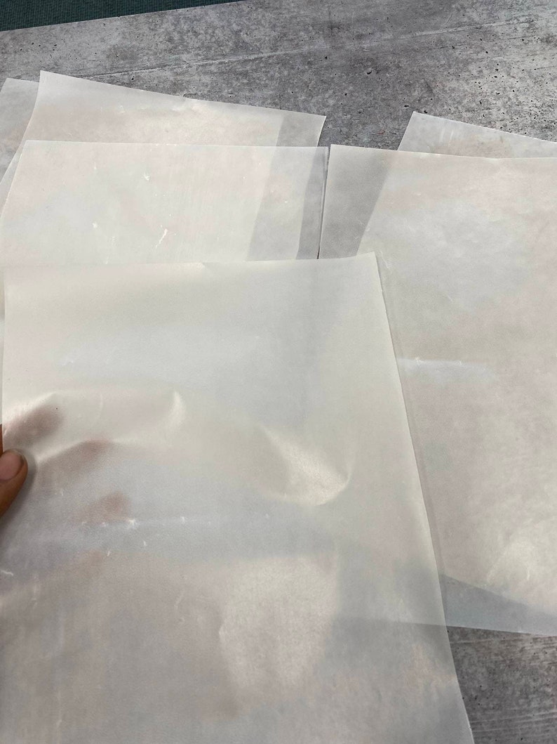 May include: A stack of translucent white sheets of parchment paper.