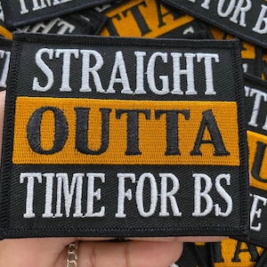 May include: A black and yellow embroidered patch with the text "Straight Outta Time For BS".