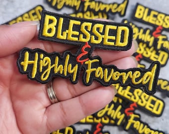 Könnte beinhalten: Schwarz-gelbe, gestickte Aufnäher mit dem Schriftzug "BLESSED & Highly Favored". Die Aufnäher sind auf einer hellgrauen Oberfläche verstreut. Ein Aufnäher wird in einer Hand gehalten.