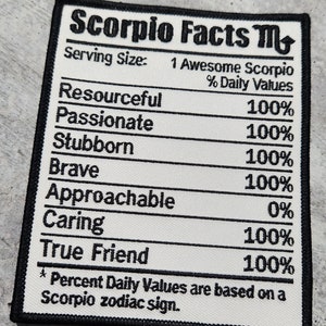 May include: A white patch with black text and a black border. The text reads "Scorpio Facts M" and lists traits of the Scorpio zodiac sign with a percentage value for each trait. The traits listed are: Resourceful, Passionate, Stubborn, Brave, Approachable, Caring, and True Friend. The text at the bottom reads "* Percent Daily Values are based on a Scorpio zodiac sign."