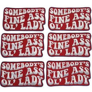 May include: Six red embroidered patches with the text "SOMEBODY'S FINE ASS OL' LADY" in white, stylized lettering. The patches are rectangular with a dark blue border.
