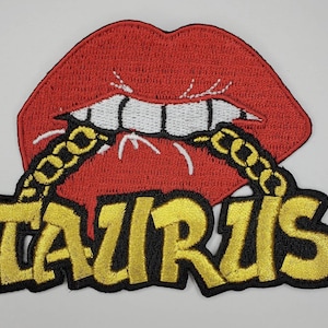 May include: Embroidered iron-on patch featuring a red, open mouth with white teeth and a gold chain, with the word "TAURUS" in gold letters below.