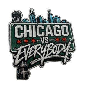 Puede incluir: Un parche bordado con forma de señal de calle verde con el texto CHICAGO VS EVERYBODY en blanco y negro. Sobre la señal hay un horizonte urbano en azul y negro. El diseño incluye tres estrellas rojas de seis puntas y una base de poste.