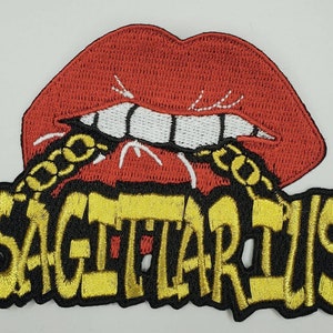 May include: Embroidered iron-on patch with a red, open mouth with gold chain teeth and the word "SAGITTARIUS" in yellow letters on a black background.