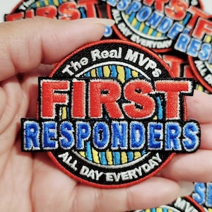 Op de afbeelding: Een geborduurde patch met de tekst "The Real MVPs First Responders All Day Everyday" in rood, wit en blauw.