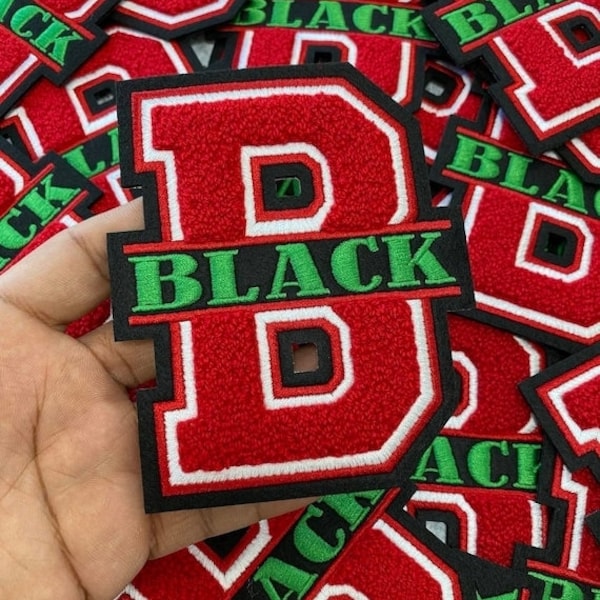 Op de afbeelding: Rode en zwarte geborduurde patches met de letter "D" en het woord "BLACK" in groen. De patches hebben een witte rand. De afbeelding toont meerdere patches, waarschijnlijk voor kleding of accessoires.