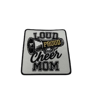 May include: A square embroidered patch with a white background and a black border. It features a black megaphone graphic with the word PROUD in gold thread. The text LOUD is above the megaphone, and the words Cheer MOM are below in black.