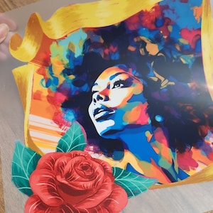 May include: A colorful abstract portrait of a woman with a red rose and green leaves in the foreground. The woman's hair is styled in an afro and she is looking up. The background is a yellow banner with a colorful abstract design.