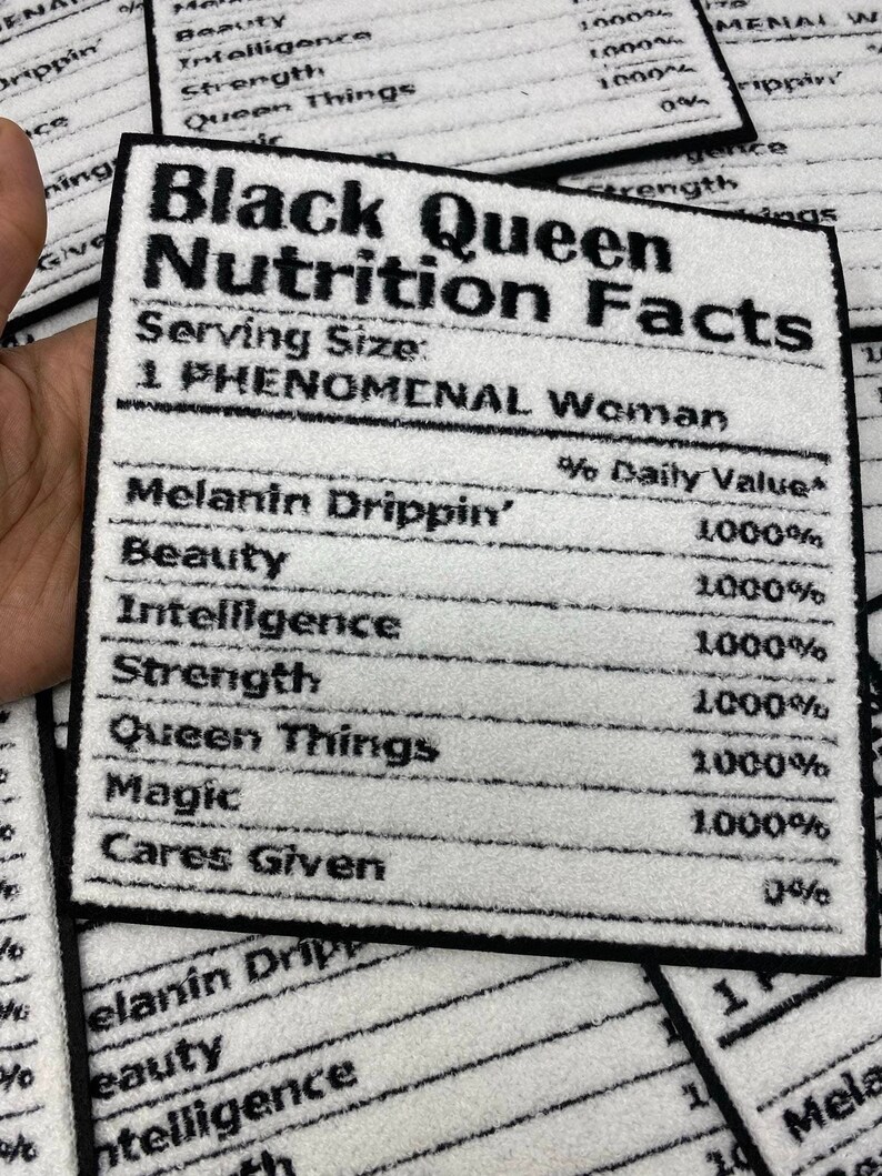 May include: A white and black rectangular patch with the text "Black Queen Nutrition Facts." The patch lists "Melanin Drippin'," "Beauty," "Intelligence," "Strength," "Queen Things," "Magic," and "Cares Given" with 1000% daily value.