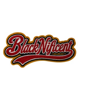May include: An embroidered patch featuring the text BlackNificent in a red script font with a white outline and black shadow. The design is set against a gold-colored background with a red swoosh underline, creating a bold, layered appearance.