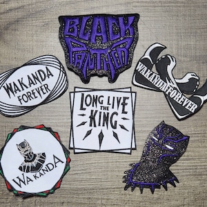 Può includere: Dieci toppe da stirare con il logo di Black Panther, il testo Wakanda Forever e il testo Long Live the King. Le toppe sono viola, nere e bianche.