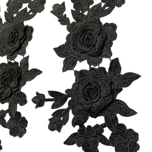 May include: Black floral lace applique featuring roses and leaves. The applique has a three-dimensional effect, with detailed stitching creating depth and texture. Ideal for embellishing clothing or craft projects.