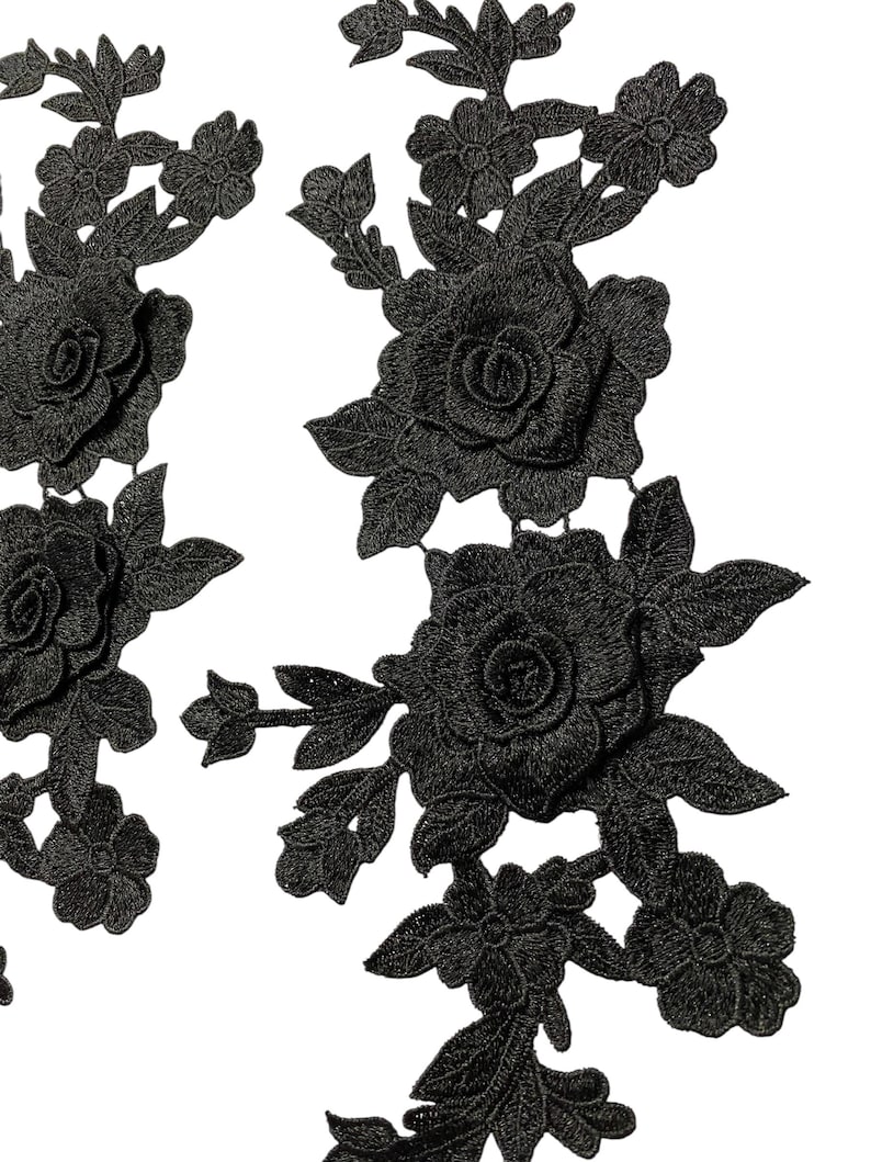 May include: Black floral lace applique featuring roses and leaves. The applique has a three-dimensional effect, with detailed stitching creating depth and texture. Ideal for embellishing clothing or craft projects.