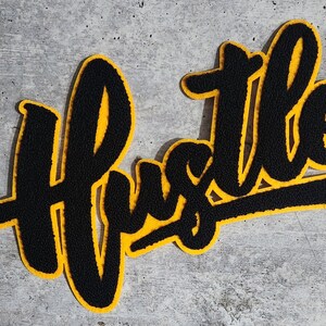Parche de chenilla "Hustle" negro y dorado (para coser o pegar), tamaño 23 x 16,5 cm, ideal para vaqueros, camuflaje y sudaderas.