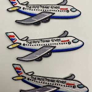Puede incluir: Tres parches bordados de un avión blanco con ribetes azules y detalles rojos. El avión tiene el texto "True World Traveler Airways" en el lateral.