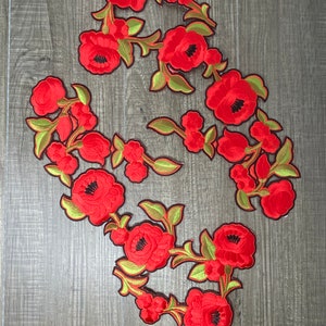 May include: A set of five red embroidered floral patches with green leaves and stems. The patches are perfect for adding a touch of vintage charm to clothing, bags, or home decor.
