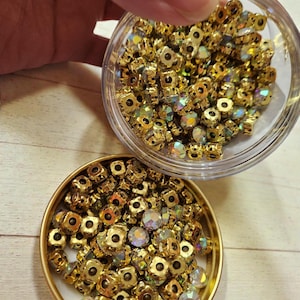 Peut inclure: Une tasse en céramique blanche avec une anse noire et l'inscription "But First, Coffee" en noir, dans une police manuscrite. La tasse est posée sur une surface blanche.