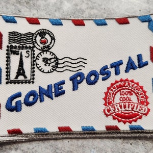 May include: Embroidered patch in the shape of an envelope with red and blue trim. Features the text "GONE POSTAL" in blue, along with postage stamps and a "100% COOL CERTIFIED" seal.