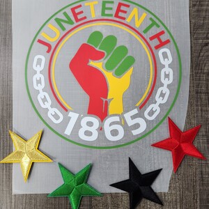 May include: A white circle with the words "Juneteenth" and "1865" in a black and green circle with a raised fist in the center. The fist is red, yellow, and green. There are three stars in the corners of the image: gold, green, and black.