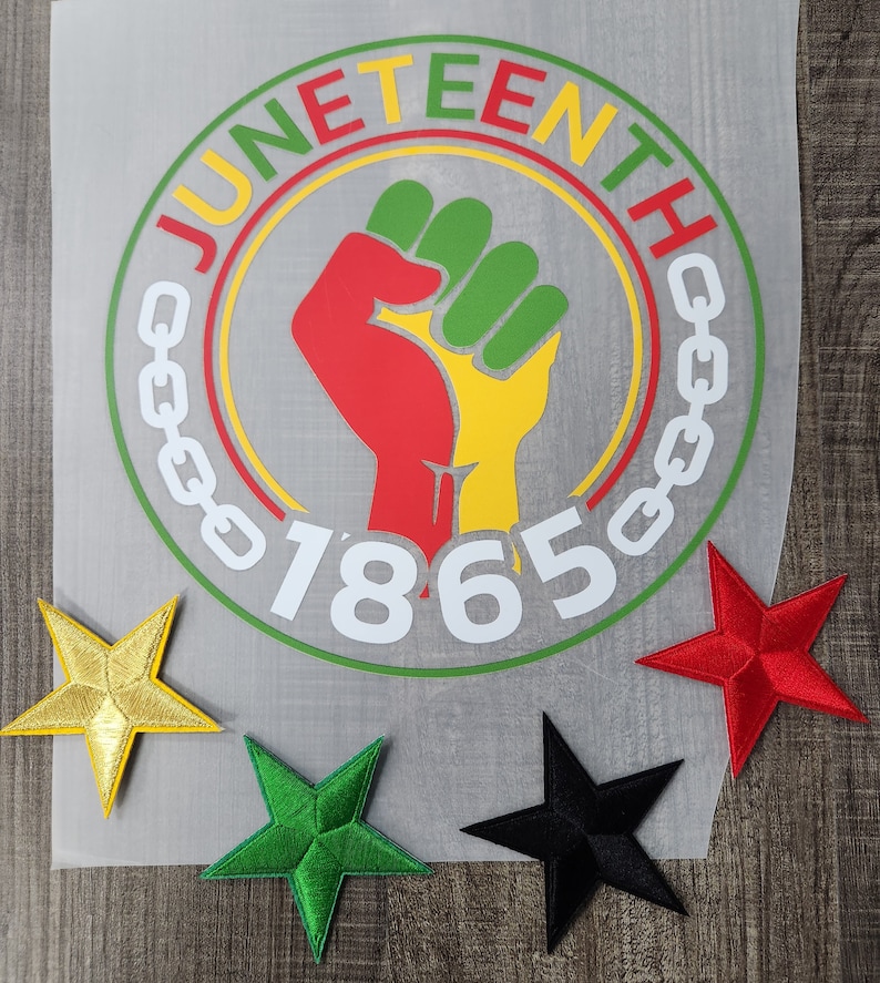 May include: A white circle with the words "Juneteenth" and "1865" in a black and green circle with a raised fist in the center. The fist is red, yellow, and green. There are three stars in the corners of the image: gold, green, and black.