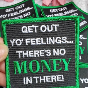 May include: Black and green embroidered patch with white text that reads "Get out yo' feelings... There's no money in there!"
